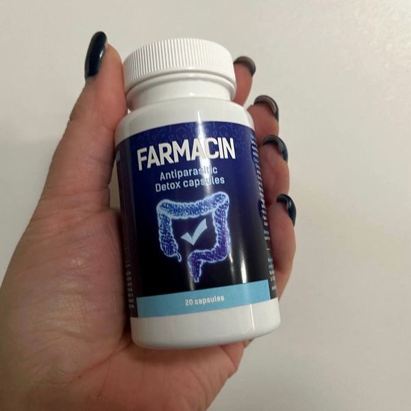 Farmacin kapszula fehér-sötétkék flakonja kézben tartva