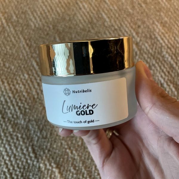 Lumiere Gold arckrém tégelye arany fedéllel, kézben tartva