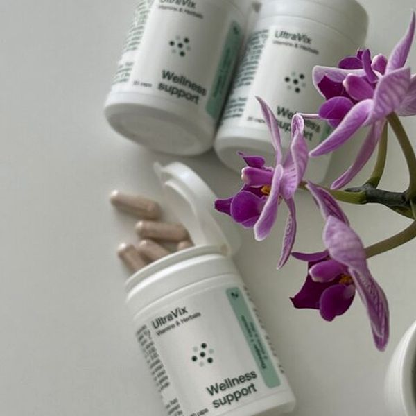 Három fehér UltraVix flakon lila orchidea mellett